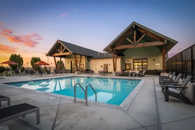 Outdoor pool with seating and sunset view.