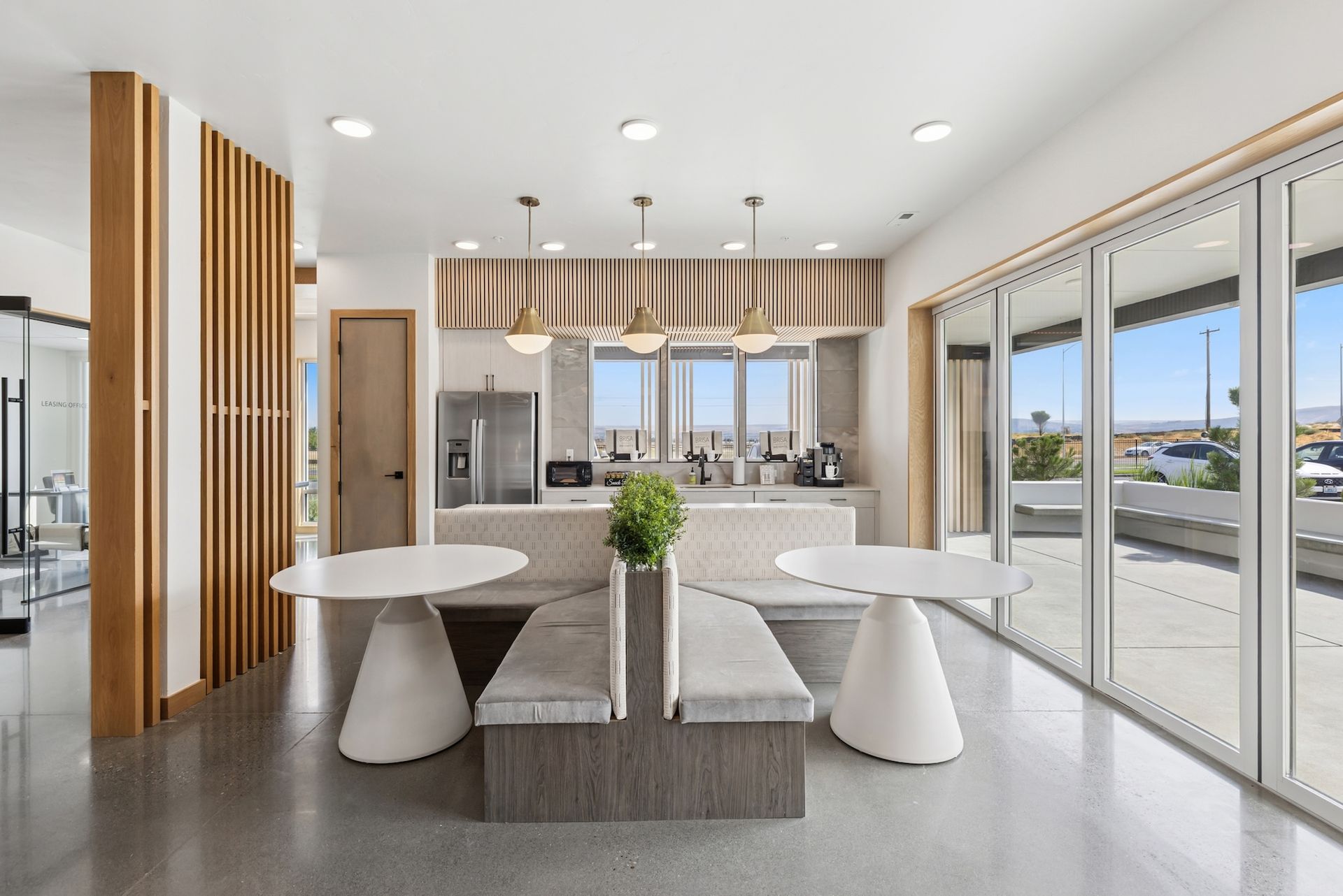 Modern kitchen with large windows and seating area.