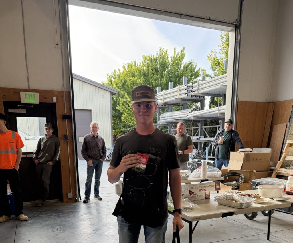 Young man holding card in workshop doorway