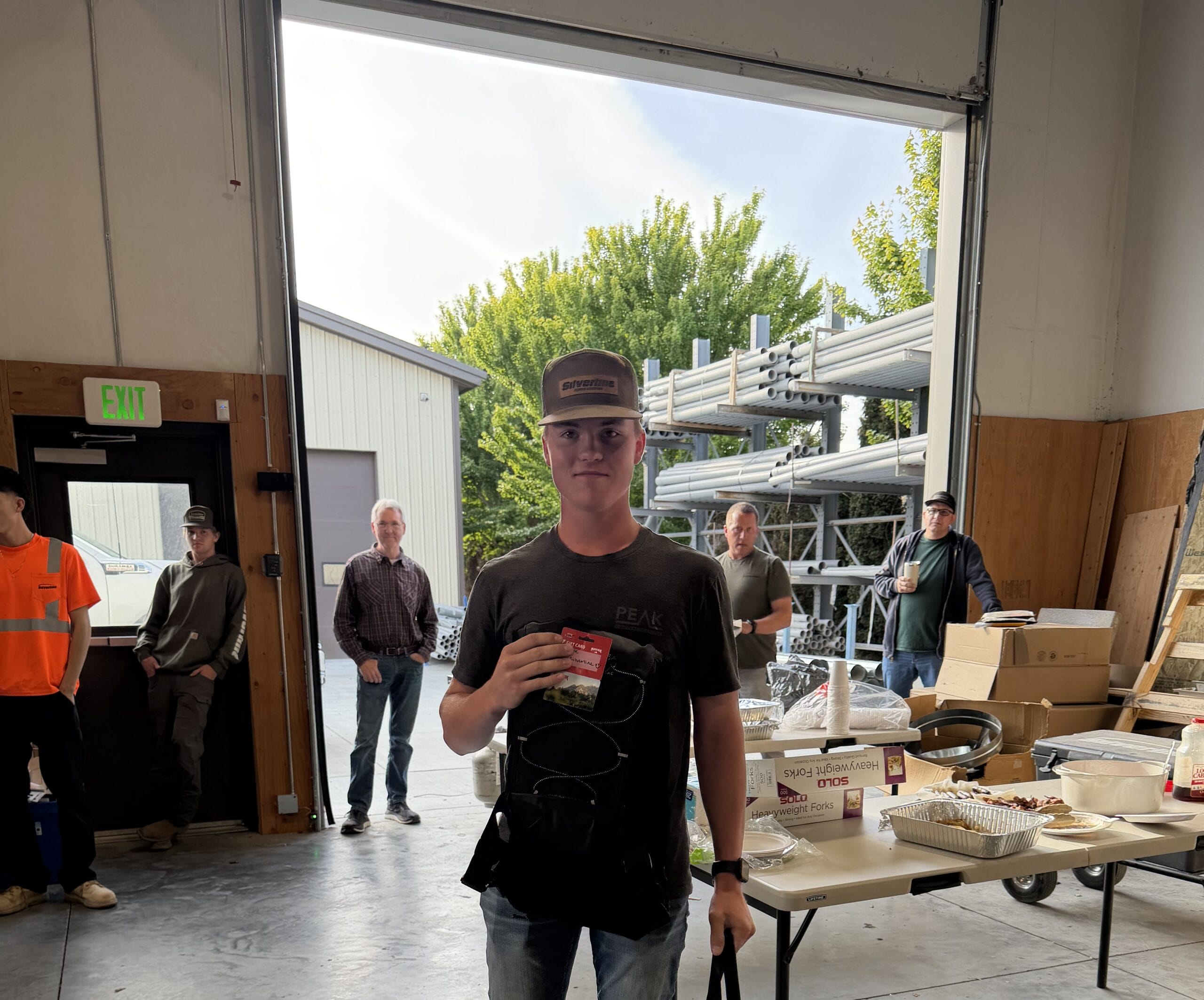 Young man holding card in workshop doorway