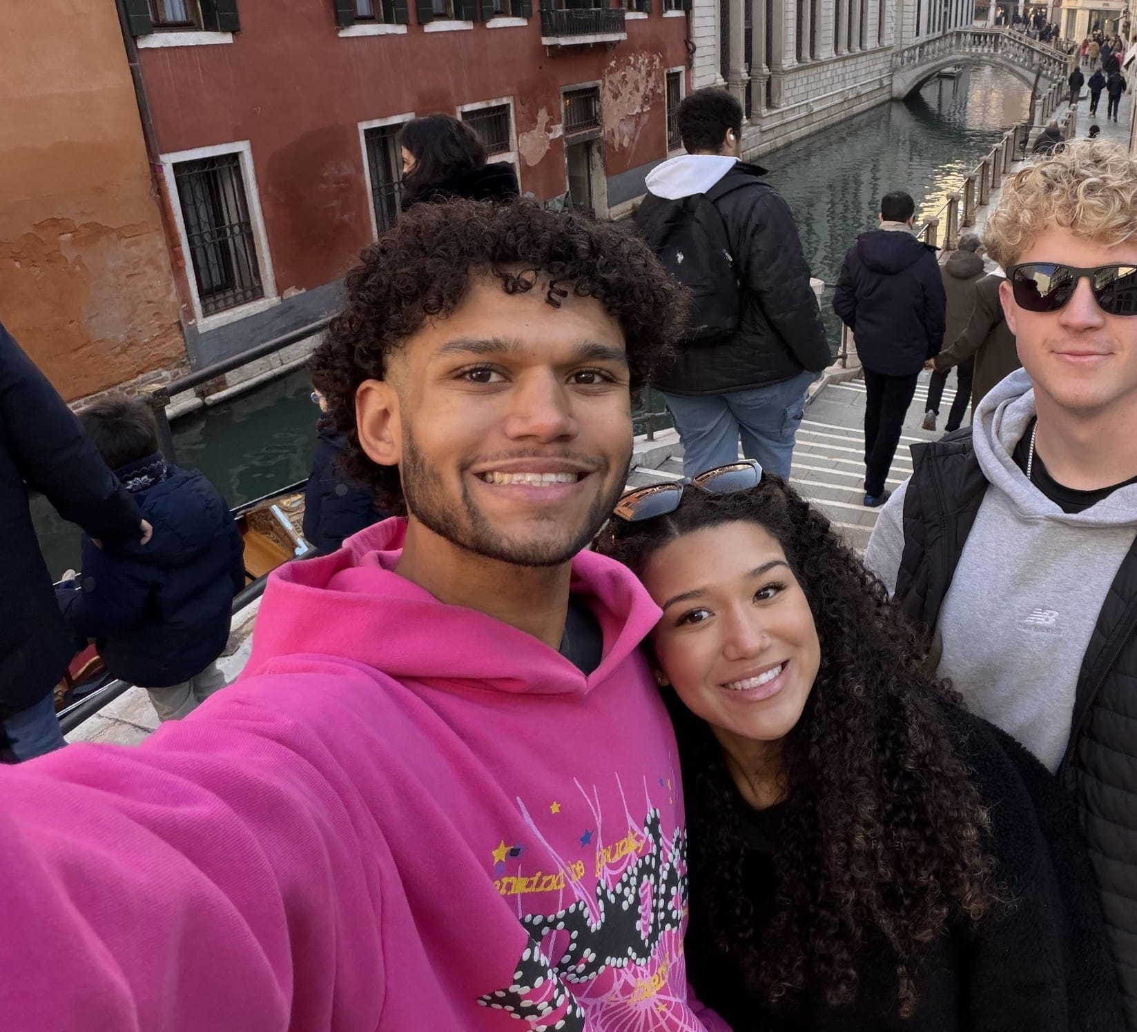 Three friends take a selfie beside a Venice canal.