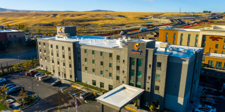 Modern hotel building with parking lot, aerial view.