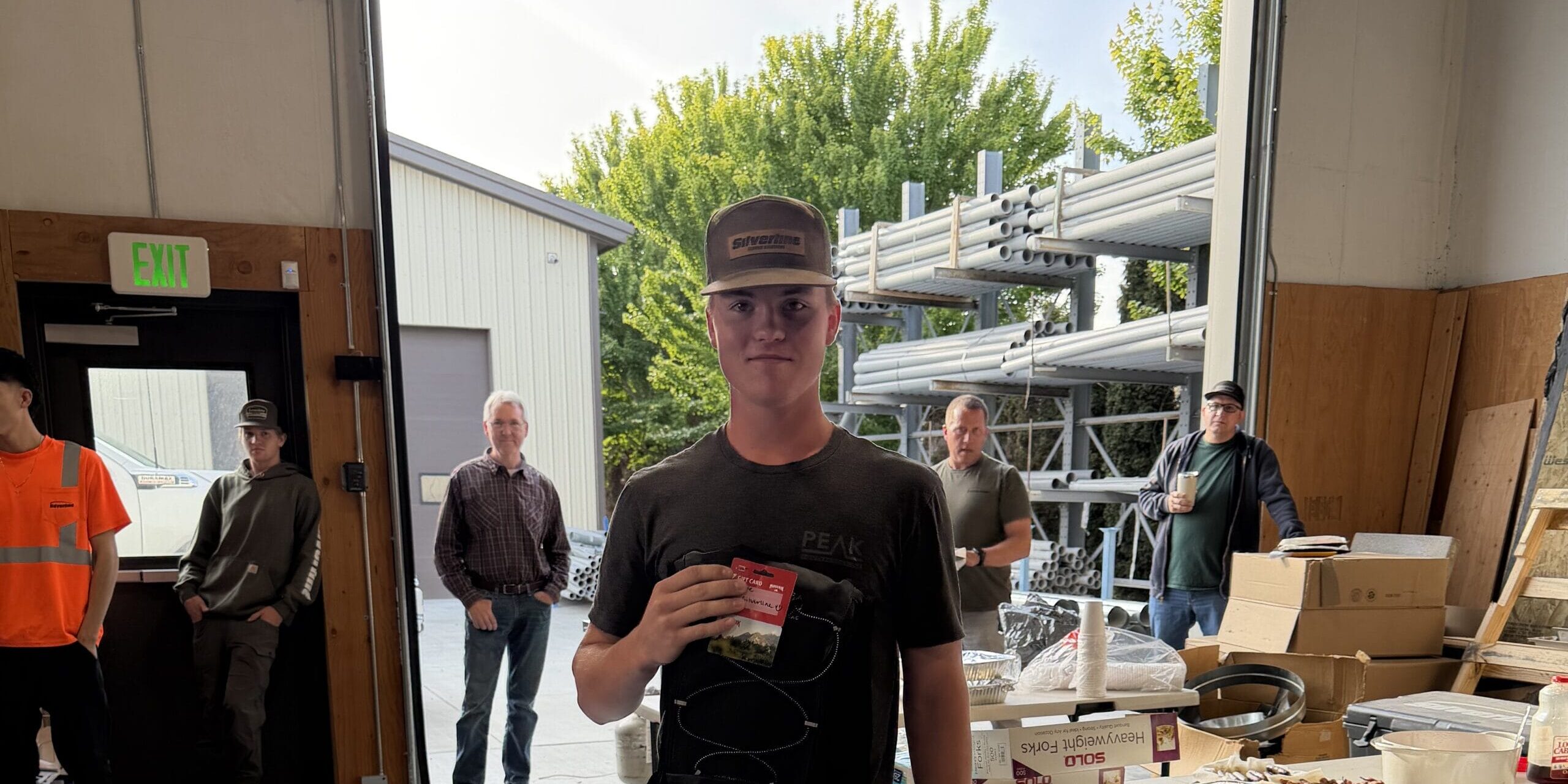 Young man holding card in workshop doorway